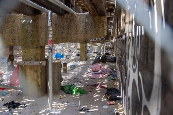 Discarded blankets, clothes and trash underneath the Coney Island boardwalk,